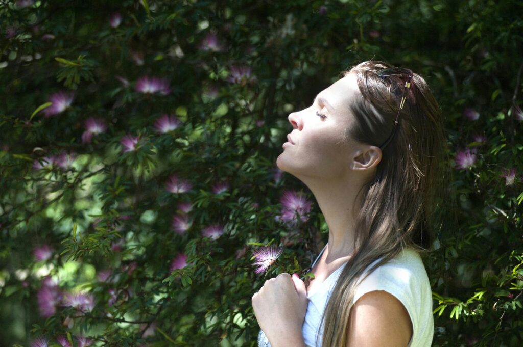 Individu pratiquant la méditation ou respiration consciente en pleine nature pour améliorer sa santé mentale.